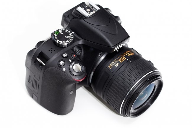 Nikon D3300 + 18-55 mm VR II: Frontansicht mit Moduswahlrad, Auslöser und Blitz