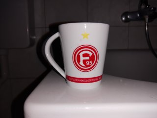 Dank hellem LED-Blitzlicht und sicher zupackendem Autofokus erscheint die Fortuna-Düsseldorf-Tasse mit Meisterstern recht detailgetreu